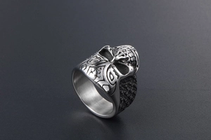 Detailed macro view of vintage skull carving on stainless steel ring with grid pattern