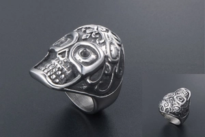 Macro detail of gothic skull ring with vintage floral embossed patterns in titanium steel
