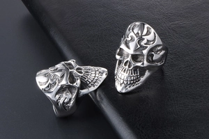 Macro shot of punk skull ring with gothic tribal carvings on black leather background