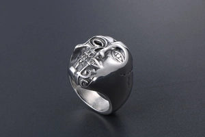 Détail d'une bague punk en acier inoxydable avec motif visage et crâne sculptés