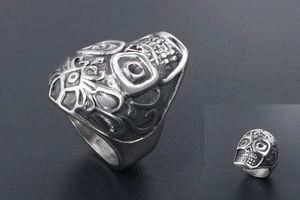 Detailed view of silver sugar skull ring with antique texture and floral engravings