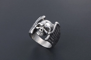 Macro detail of gothic skull ring with angel wings in vintage silver steel finish