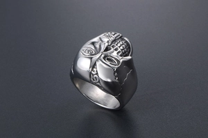 Détail macro de la bague gothique en acier inoxydable au design visage et crâne