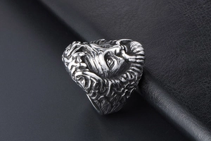 Dettaglio macro dell'anello teschio punk gotico con piume di capo su pelle nera