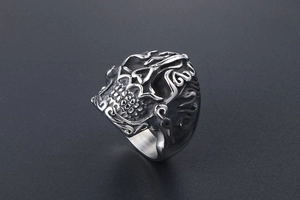 Detail view of vintage silver skull ring with gothic flames and punk relief textures