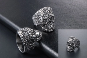 Detail of vintage punk skull ring with intricate mandala floral carvings in silver steel