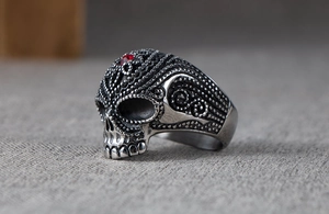 Macro detail of gothic skull ring featuring red gemstone and vintage steel finish