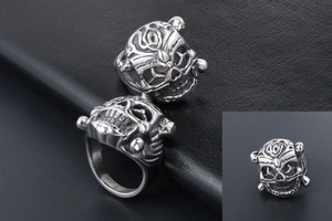 Detailed close-up of punk style skull ring with intricate floral carvings in vintage silver