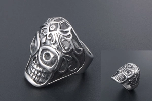 Macro shot of vintage skull ring featuring intricate floral patterns and distressed steel finish