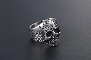 Macro shot of skull ring with intricate forehead engravings and rustic textured steel