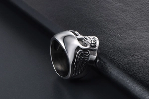 Vue macro d'une bague crâne punk avec textures d'ailes sur anneau en acier vintage