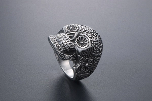 Macro detail of gothic vampire skull ring with intricate floral engraving on matte steel