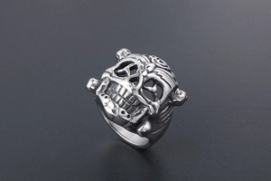 Macro detail of silver stainless steel skull ring with intricate punk carvings