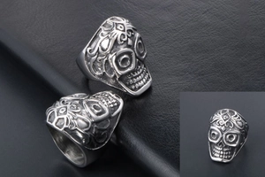 Detailed close-up of gothic skull ring with intricate floral carvings in vintage steel