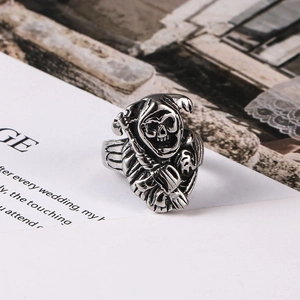 Gothic punk reaper skull ring in antique silver finish on a vintage background