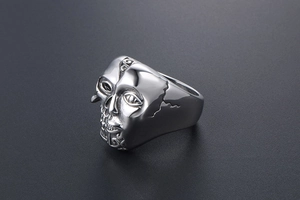 Détail d'une bague gothique en acier inoxydable avec design de masque et gravure fine