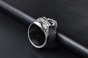 Macro side view of vintage skull ring with detailed totem carvings on thick steel band