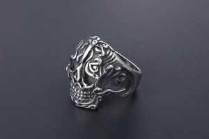 Macro detail of vintage skull ring featuring intricate flame patterns in antique silver finish