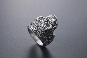 Macro shot of punk style stainless steel skull ring with vintage floral carvings