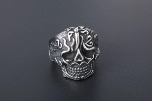 Detailed close-up of retro skull ring with ornate floral patterns in oxidized titanium steel