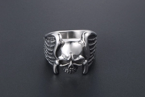 Detailed macro shot of a skull ring with wing textures in polished stainless steel