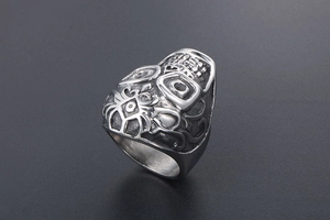 Macro detail of gothic skull ring in silver titanium steel with intricate embossed pattern
