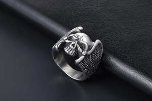 Detailed close-up of gothic skull ring with feathered wings in polished stainless steel