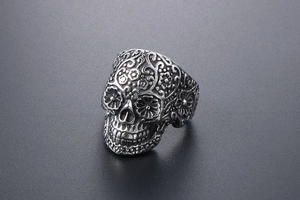 Close-up of vintage vampire skull ring with intricate floral carvings in stainless steel