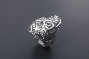 Macro detail of gothic skull ring with intricate relief patterns in vintage steel