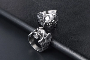 Macro detail of gothic skull ring with angel wings made of polished stainless steel
