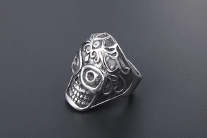 Detailed close-up of retro silver skull ring featuring intricate gothic relief carving