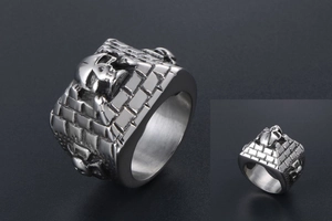 Detailed view of punk skull ring with vintage brick wall texture on stainless steel band