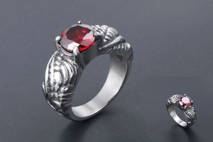 Macro detail of a vintage silver-finish ring with red crystal and wing carvings