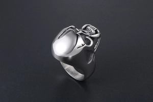 Macro side view of a polished stainless steel skull ring with gothic punk zombie teeth