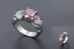 Macro detail of retro wing ring with silver engraving and a round red gemstone inlay