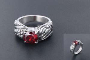 Macro shot of punk style silver wing ring featuring a central round red gemstone
