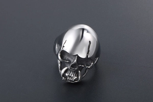 Detailed close-up of a silver skull ring with polished metal brow and punk gothic accents