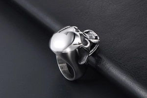 Macro shot of silver titanium steel skull ring with side heart detail on leather