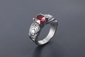 Macro shot of retro wing ring with large red round gemstone and silver feather relief