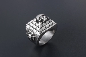 Macro detail of vintage skull ring with cross engraving and stainless steel texture