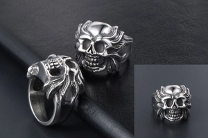 Macro shot of vintage skull ring detailing the matte silver texture and punk engravings