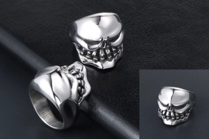 Detailed close-up of a silver skull ring with gothic punk design on leather background