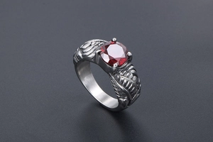Macro view of silver wing relief details and faceted red gemstone on retro ring