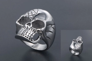 Detail view of punk skull ring with intricate mesh texture and polished steel finish