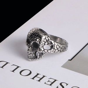 Macro shot of punk skull ring featuring detailed scale textures and vintage silver finish