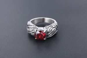 Detailed view of silver wing relief carving and large red gemstone on vintage ring