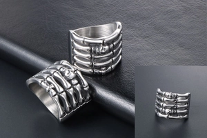 Detailed view of silver skull bone ring in punk style on black leather background