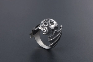 Detailed side view of vintage bat wing and skull ring in antique silver finish