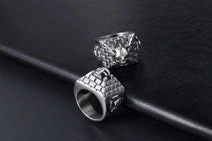 Detailed close-up of a men's punk ring with skull relief and pyramid wall texture