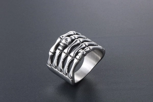 Macro detail of gothic titanium steel ring featuring skeleton bone and cross patterns